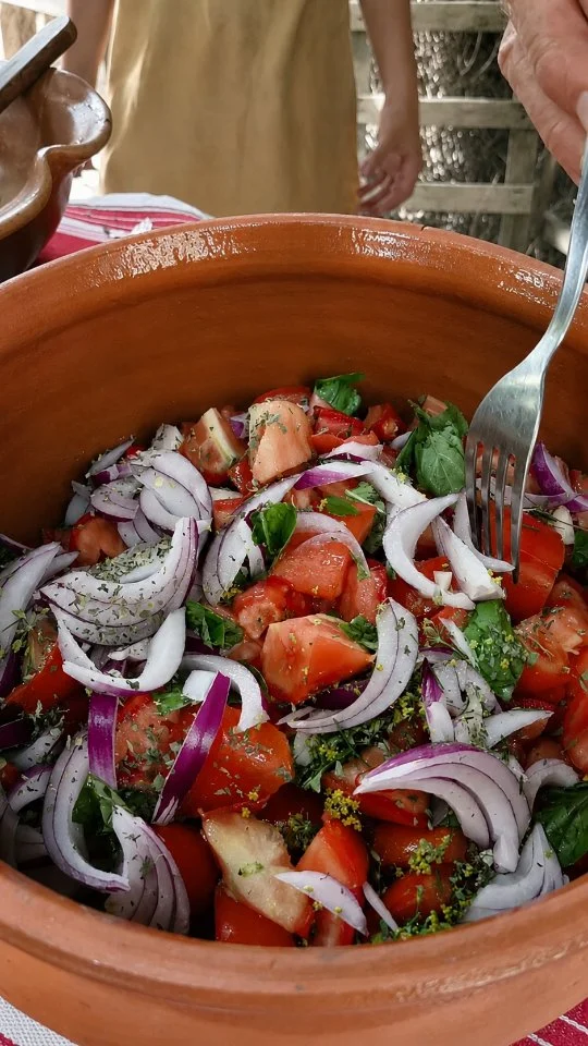 A nzalata i pimmadori paisana - L'insalata di pomodori paesana

Franca apre le porte della sua casa di campagna per accogliere con il calore di sempre alcuni amici arrivati dal New Jersey, ma con il cuore profondamente legato alla Calabria. Anche se la tradizionale giornata dedicata al pane viene rimandata, la convivialità non manca: insieme preparano una vera insalata di pomodori paesana, proprio come la facevano i nonni. Tra i profumi dei pomodori "a Campanedu", dell'aglio di Papaglionti, del basilico, dell'origano, del finocchietto selvatico e del peperoncino appena raccolto, Franca racconta antichi gesti e piccoli segreti tramandati di generazione in generazione. Accanto a lei ci sono Adolfo, originario di Cittanova ma residente nel New Jersey, Laura e la piccola Giulia, che partecipano con entusiasmo alla preparazione, trasformando una semplice ricetta in un momento di condivisione e memoria. Il pranzo si completa con pane tostato ammollato, olio extravergine d'oliva, soppressata artigianale e un buon bicchiere di vino, proprio come nelle tavole di una volta. Tra sorrisi, racconti e il celebre invito di Franca, "Se ne volete, venite!", il video celebra l'ospitalità calabrese, il valore delle proprie radici e l'importanza di tramandare ai più giovani le tradizioni che raccontano la nostra storia. Un viaggio nei sapori autentici della Calabria, dove ogni ingrediente custodisce un ricordo e ogni tavola diventa un luogo d'incontro.

🇮🇹 CALABRIA 'NTO CORI ❤️
https://whatsapp.com/channel/0029VaagyAA6rsQmrBPoCW1L

🤝🏻 Sostienici: facebook.com/becomesupporter/Asfalantea/

Seguici anche su:
facebook.com/Asfalantea
tiktok.com/@asfalantea
youtube.com/@asfalantea
https://asfalantea.it

#pomodori #pummadori #cucinapaesana #insalatadipomodori #radici