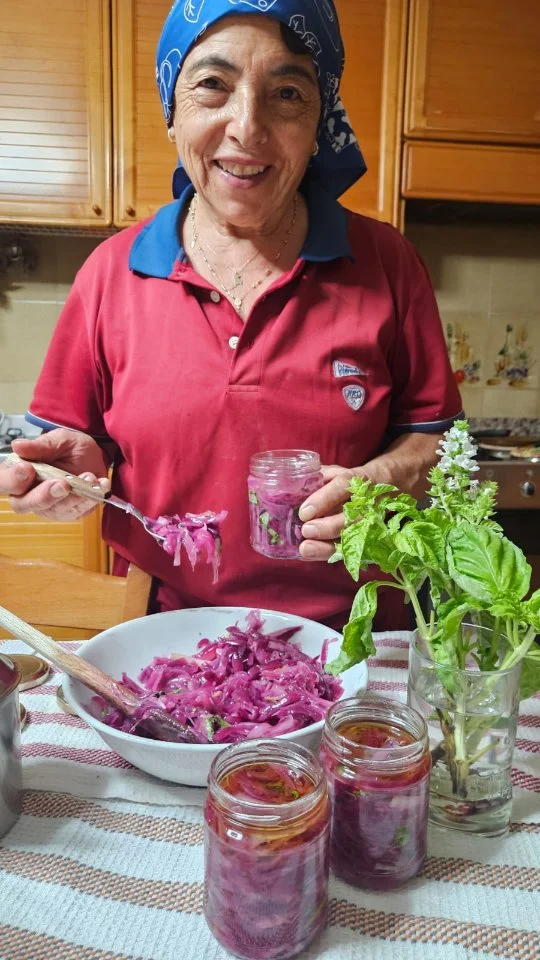 A cipuda comu a facia a nanna - La cipolla come la faceva la nonna

Una preparazione semplice e genuina, fatta secondo la tradizione: la cipolla viene prima tagliata e lasciata per circa 12 ore sotto sale, per poi essere spremuta e privata della sua acqua. Alla cipolla vengono aggiunti ingredienti aromatici come menta, basilico e origano, che ne esaltano il profumo e il sapore. Si procede quindi con il riempimento dei vasetti, mettendo prima un po’ di olio sul fondo e aggiungendo successivamente la cipolla, facendo attenzione a non riempire il contenitore fino all’estremità. Dopo il riempimento viene aggiunto altro olio, anche per evitare la presenza di aria, e i vasetti vengono lasciati riposare per un breve periodo prima di essere chiusi. Successivamente vengono fatti bollire per la sterilizzazione, così da poter essere conservati a lungo prima dell’apertura. È una preparazione naturale, senza conservanti, realizzata con cipolle coltivate in modo tradizionale, senza concimi chimici e senza trattamenti di lavaggio, ma con concime naturale. Il risultato è una cipolla dal colore rosso intenso, profumata e saporita, ideale da gustare sulle bruschette, accompagnare alla carne o semplicemente assaporare da sola. Una lavorazione fatta con cura, pazienza e rispetto per la tradizione, che porta nel vasetto tutto il gusto autentico di un prodotto del territorio.

🇮🇹 CALABRIA 'NTO CORI ❤️
https://whatsapp.com/channel/0029VaagyAA6rsQmrBPoCW1L

🤝🏻 Sostienici: facebook.com/becomesupporter/Asfalantea/

Seguici anche su:
facebook.com/Asfalantea
tiktok.com/@asfalantea
youtube.com/@asfalantea
https://asfalantea.it

#cipollarossa #cipuda #sapuricalabrisi #sapori #genuino